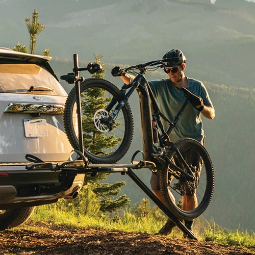Person loading an e-bike onto their e-bike rack