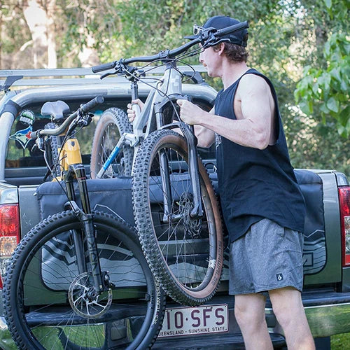 Ute tailgate with a person lifting a bike off